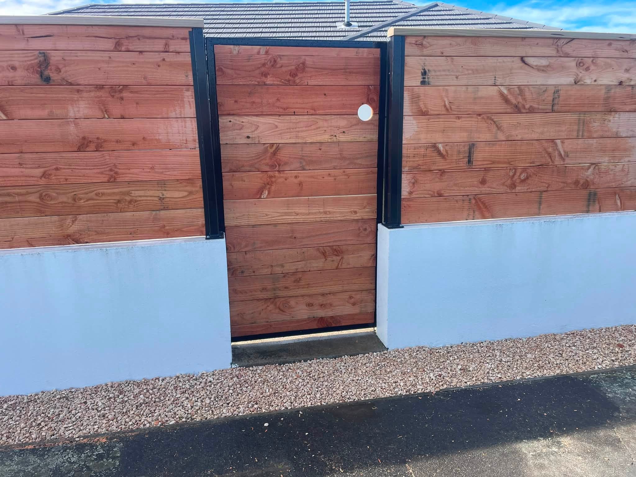 Matching timber pedestrian gate between dark posts