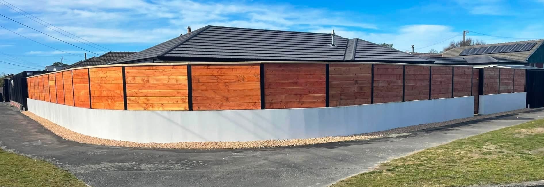 Wolf Fencing timber boundary fence with dark posts and a matching pedestrian gate